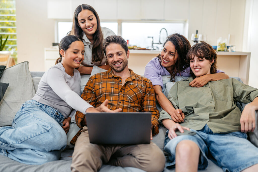 Young family using laptop while sitting in the living room in Sydney in Australia.