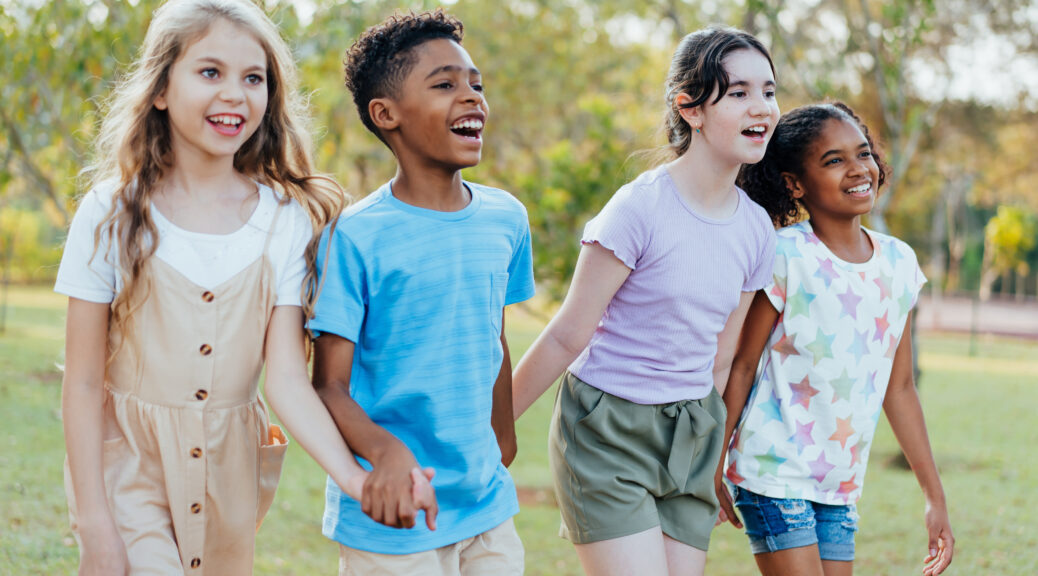 Group of children walking hand in hand in the public park