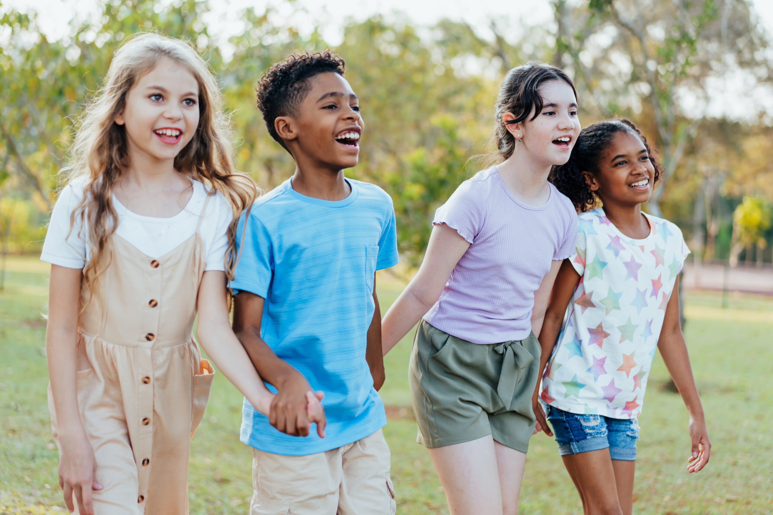 Group of children walking hand in hand in the public park