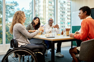 Diverse group of corporate professionals sitting around conference table and discussing ideas for project development.