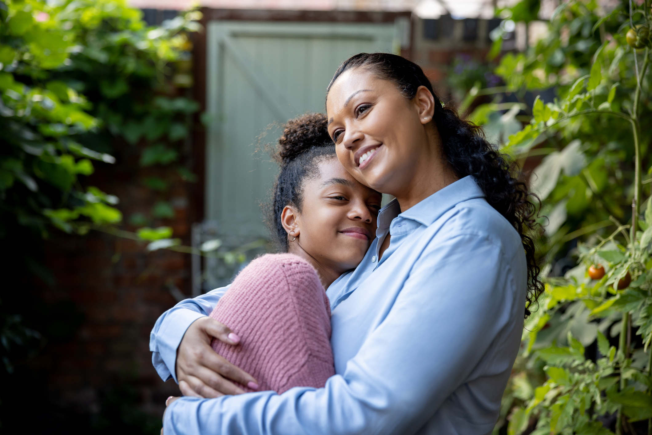 Loving mother and daughter hugging outdoors