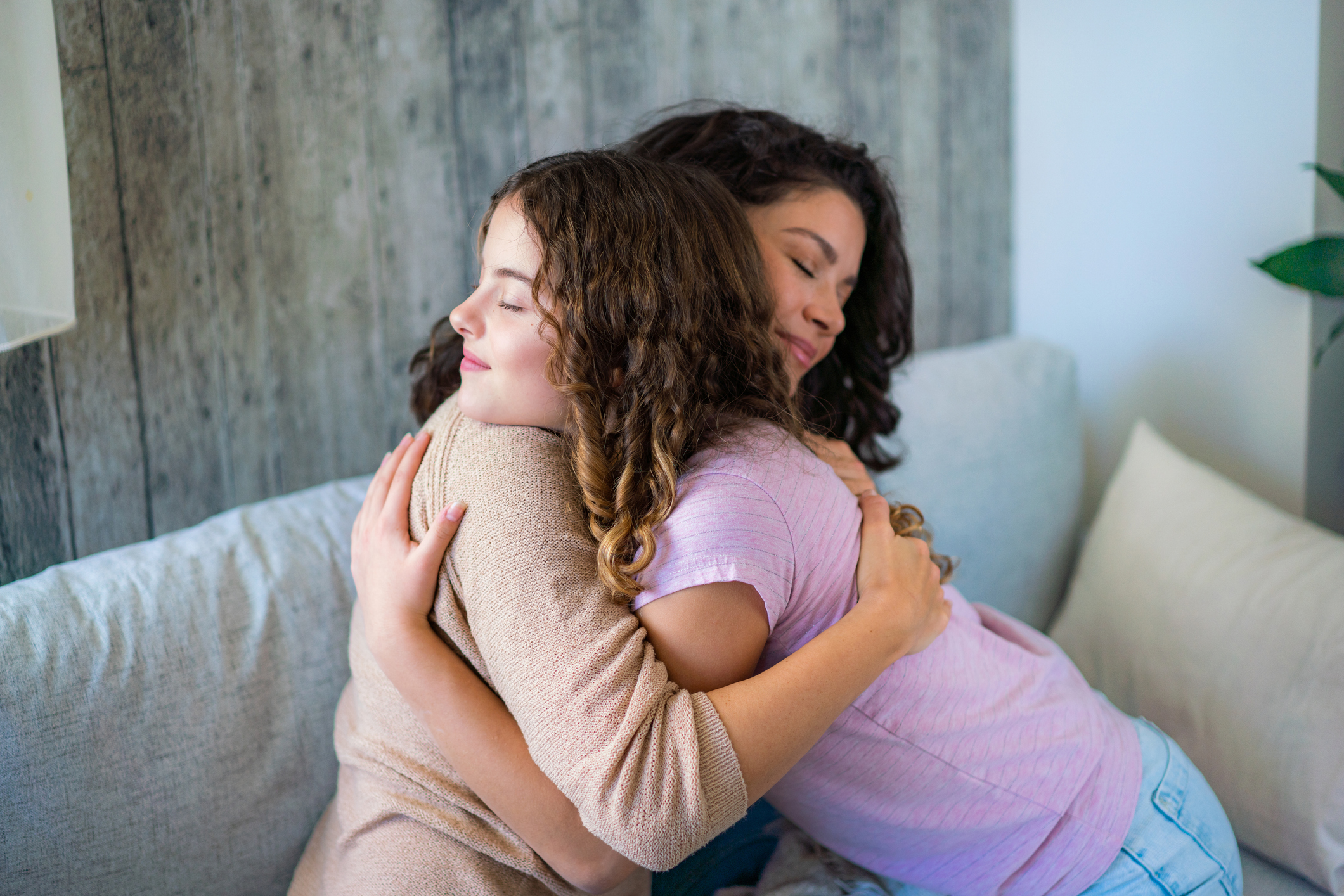 A warm hug of a mother and her teenage daughter at home