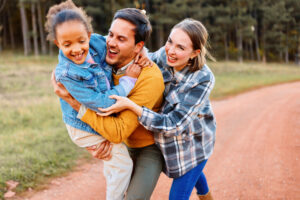 Parents bonding with adoptive daughter during walk in a nature