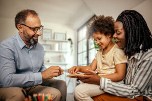 Little girl choosing toy with male psychologist