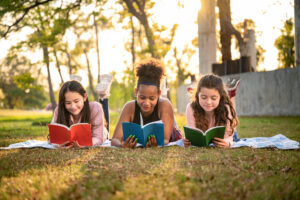 Student girl lie down reading book with sunset in the school park