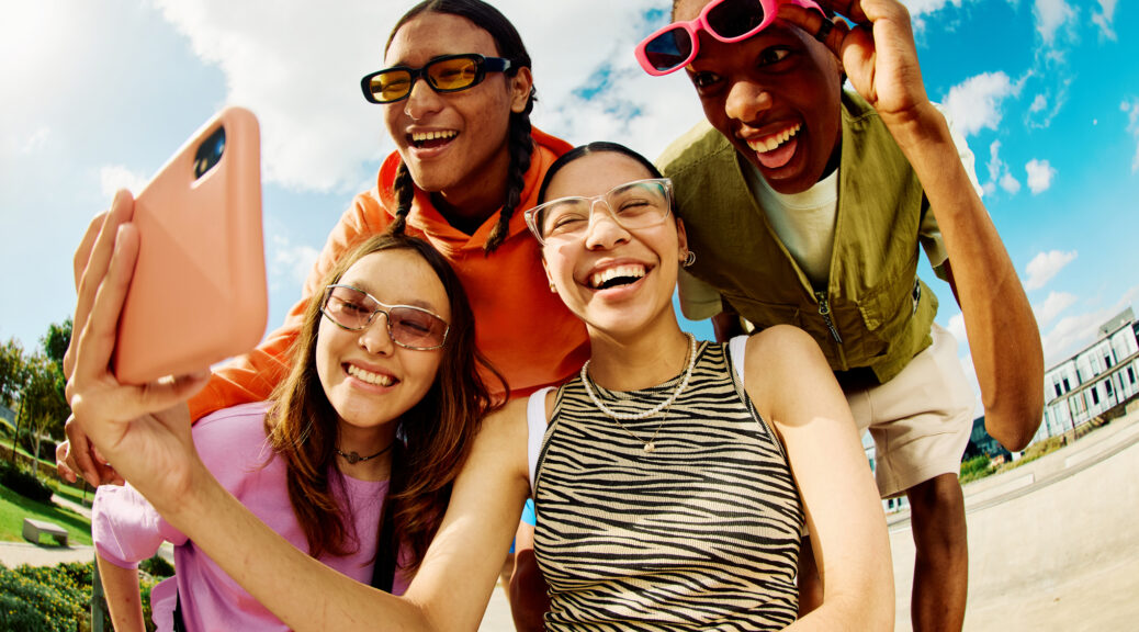 Carefree Generation Z Friends using smartphone for social media.